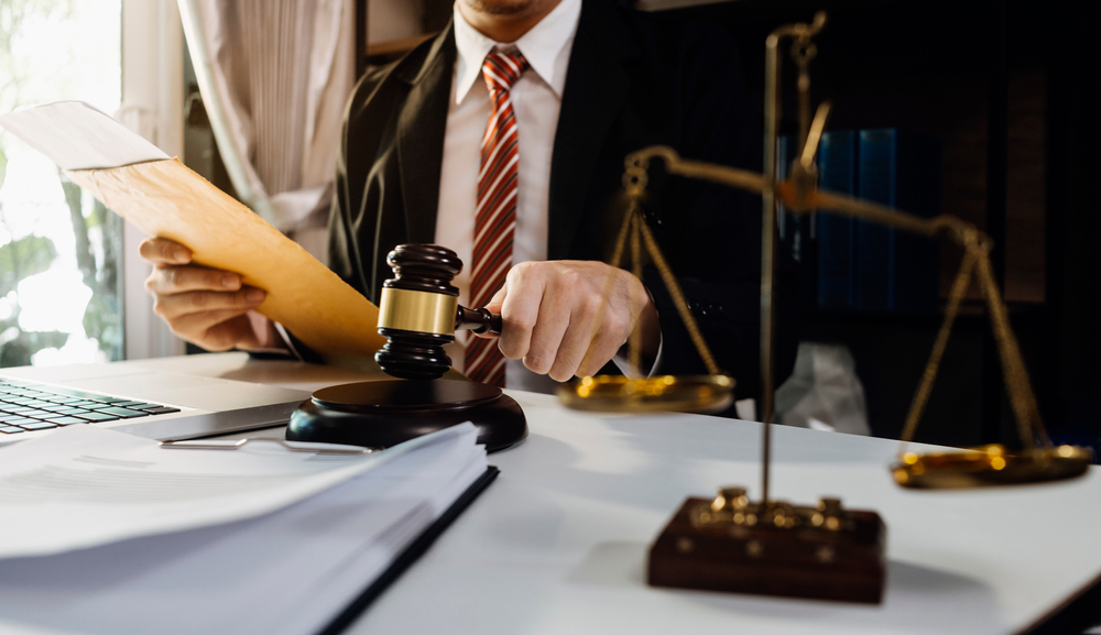Lawyer sitting at table with gavel and document